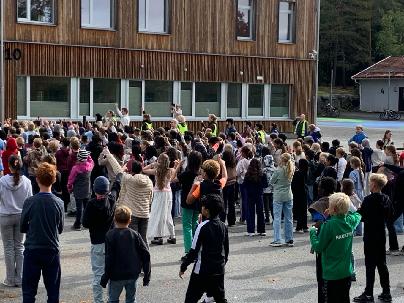 en gruppe mennesker som står utenfor en bygning