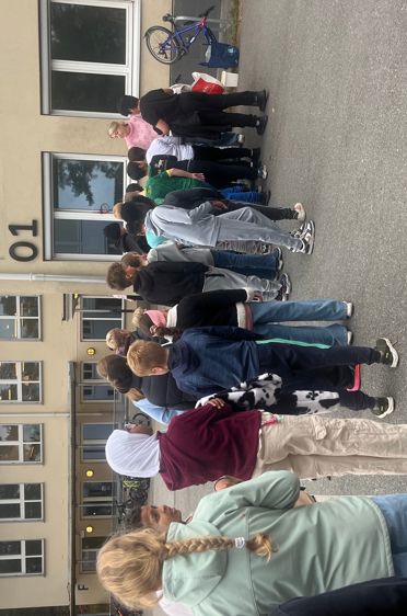 en gruppe mennesker som står utenfor en bygning