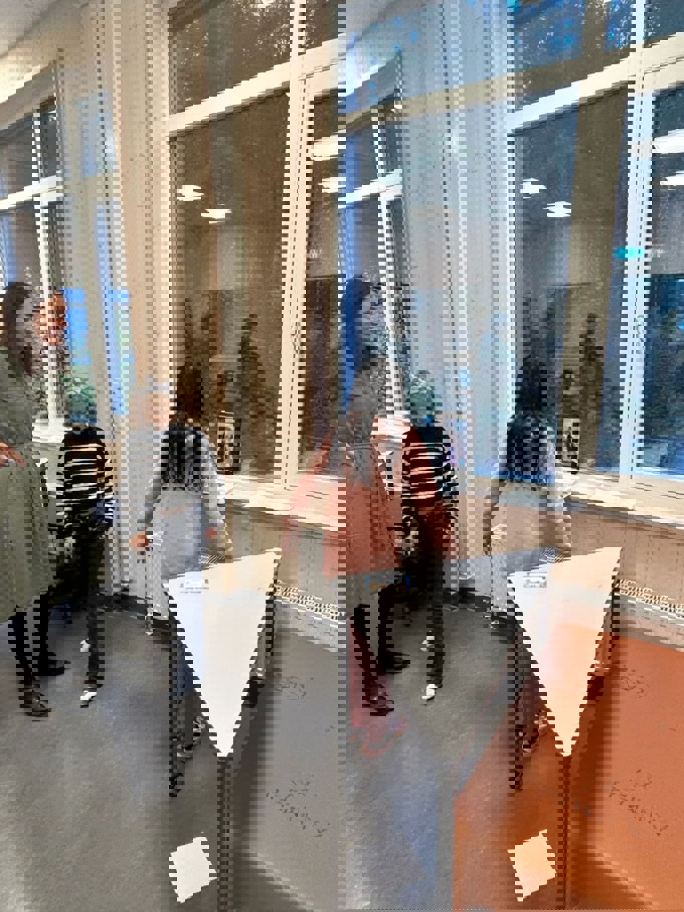 en gruppe mennesker som ser på et stykke papir på et bord