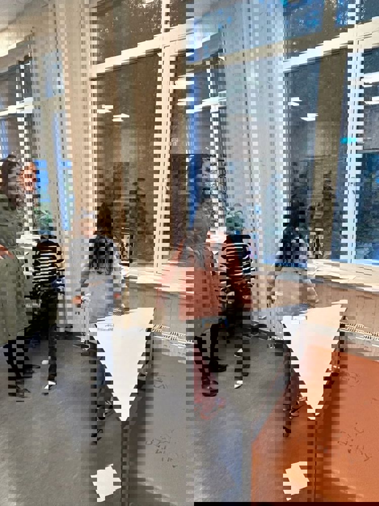en gruppe mennesker som ser på et stykke papir på et bord