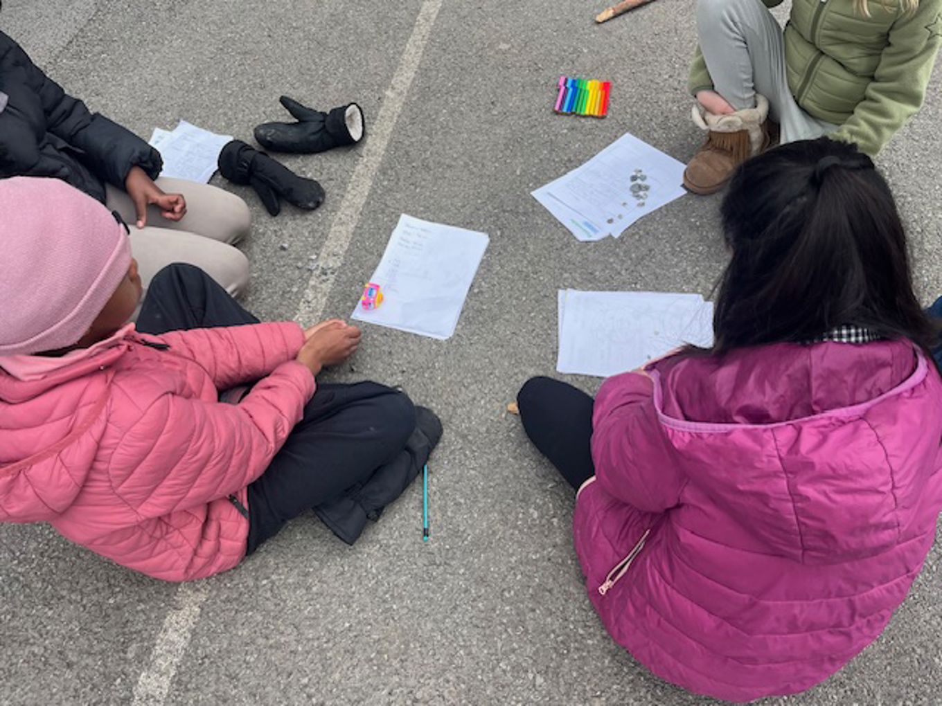 Foto: Anne Roland en gruppe mennesker som sitter på bakken og ser på papirer