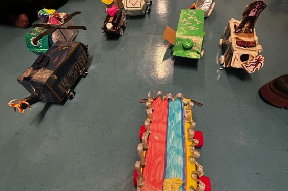 en gruppe mennesker som sitter på gulvet med leker