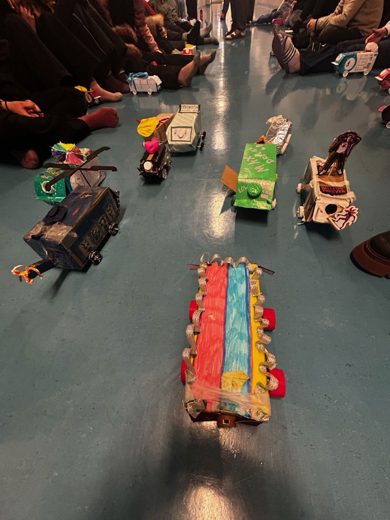 en gruppe mennesker som sitter på gulvet med leker