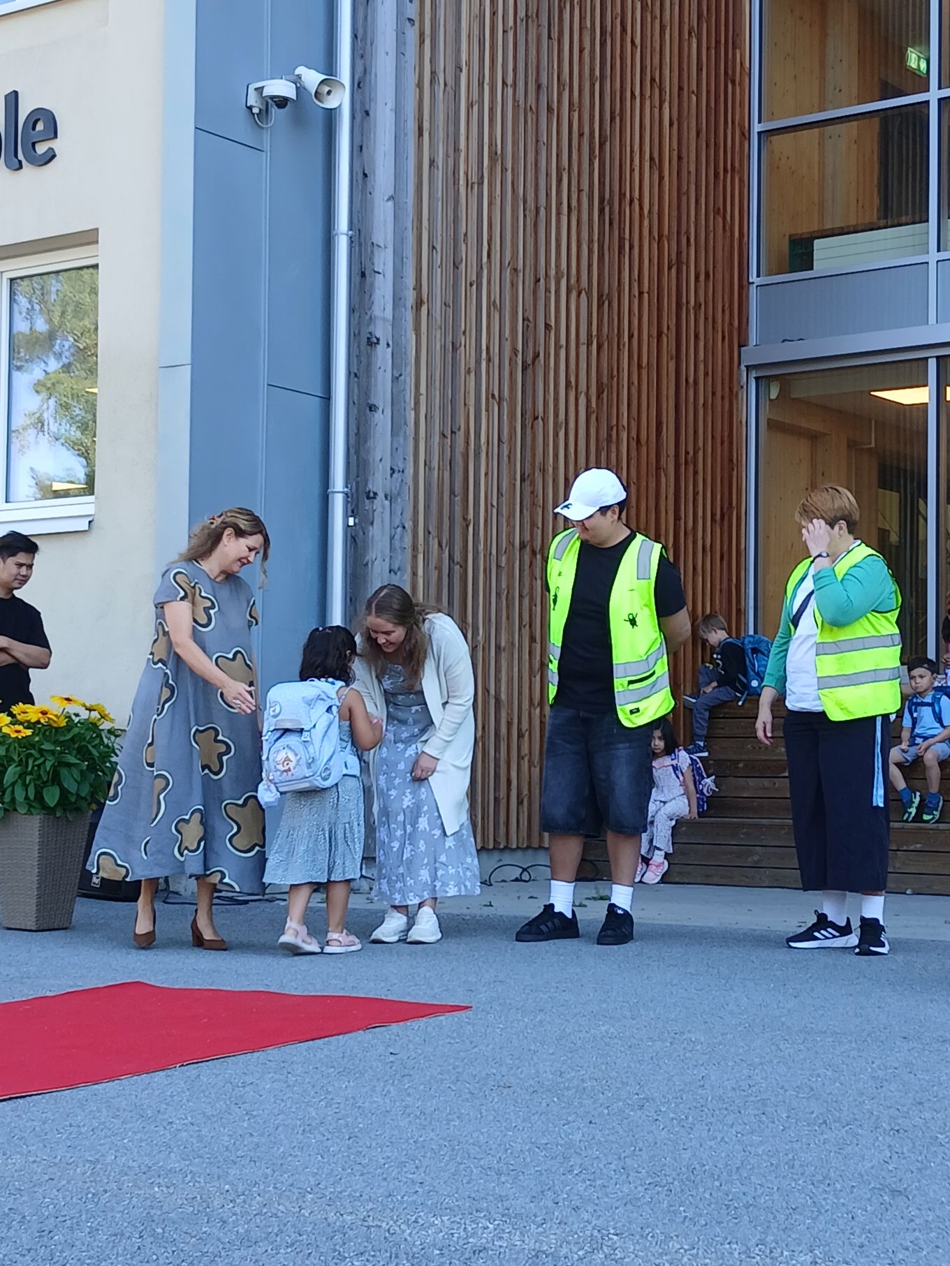 en gruppe mennesker som står utenfor en bygning