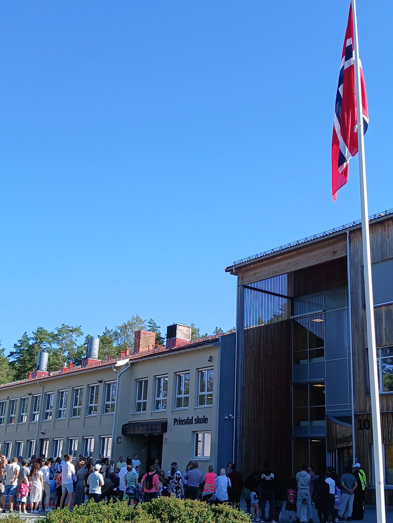 en gruppe mennesker utenfor en bygning, første skoledag