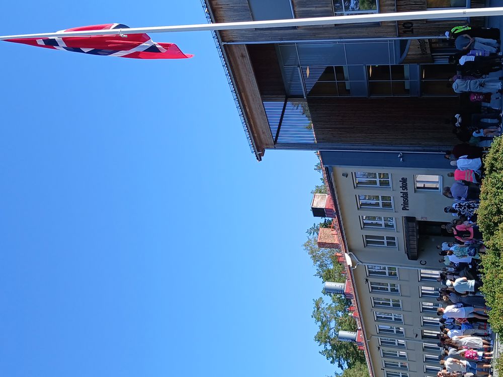 en gruppe mennesker utenfor en bygning, første skoledag